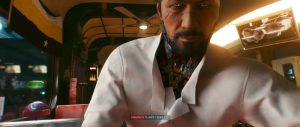 A close-up conversation scene from *Cyberpunk 2077* shows Takemura leaning toward the camera in a warmly lit futuristic interior, with soft golden light, blurred background details, and the dialogue interface visible at the bottom of the screen.